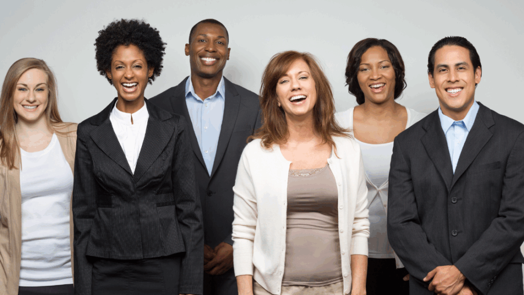 A group of six professionals smiling at the camera, showcasing diverse appearances and attire.