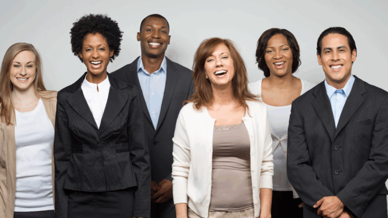 A group of six professionals smiling at the camera, showcasing diverse appearances and attire.